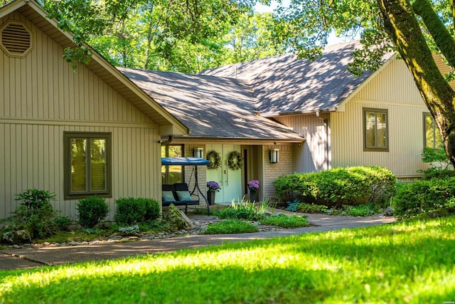 view of front of house with roof with shingles and brick siding