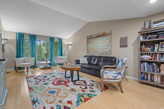 living area with lofted ceiling, baseboards, and wood finished floors