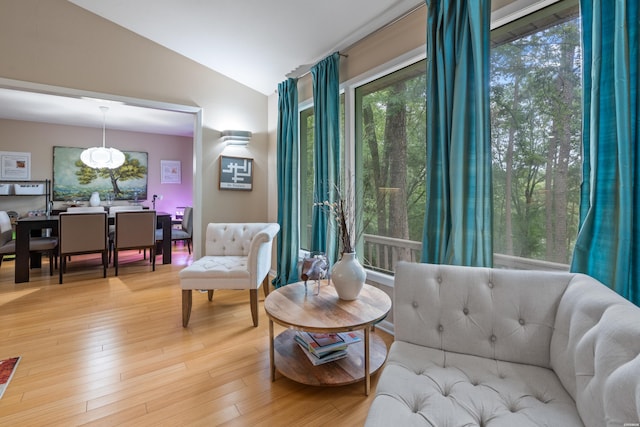 sitting room featuring lofted ceiling, light wood-type flooring, and plenty of natural light