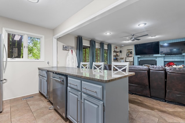 kitchen featuring a peninsula, a ceiling fan, healthy amount of natural light, appliances with stainless steel finishes, and recessed lighting