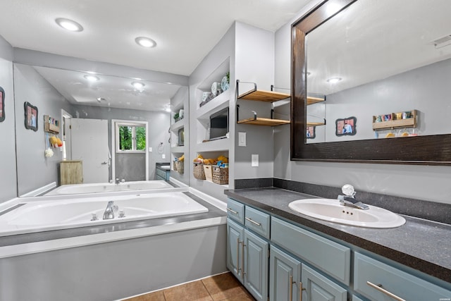 full bath with a garden tub, vanity, and tile patterned floors
