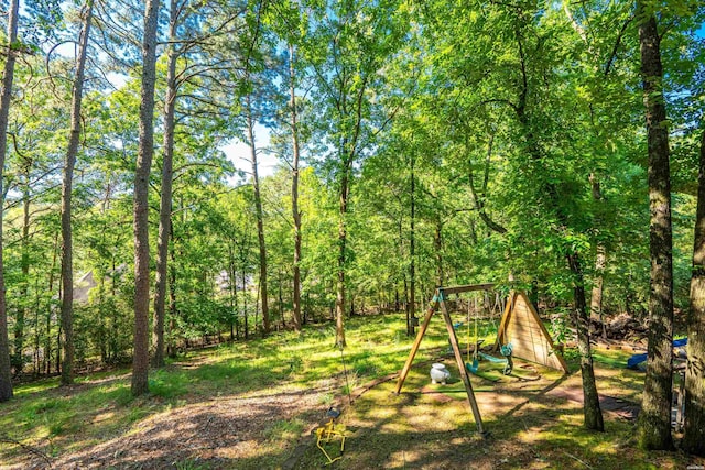 view of playground featuring a wooded view