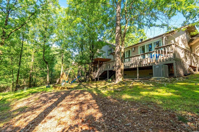 view of yard featuring stairway, central AC unit, and a deck