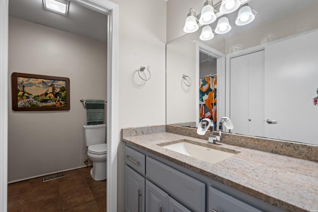 bathroom featuring toilet, vanity, and tile patterned floors