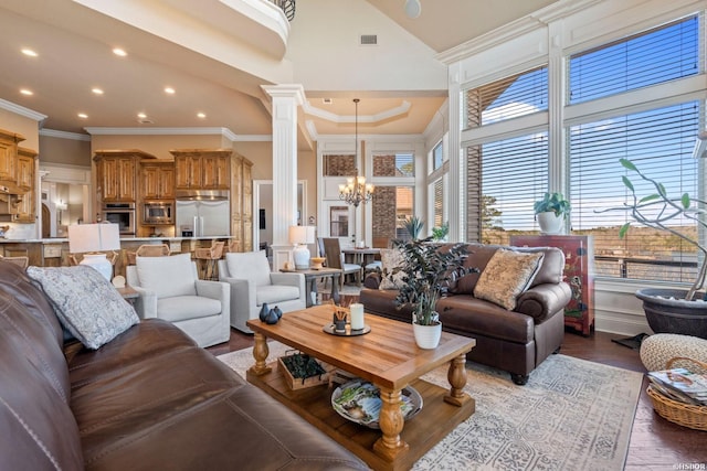 116 Lake Forest Shores Dr, Hot Springs, AR 71913 - living room featuring decorative columns, light wood finished floors, visible vents, a towering ceiling, and an inviting chandelier