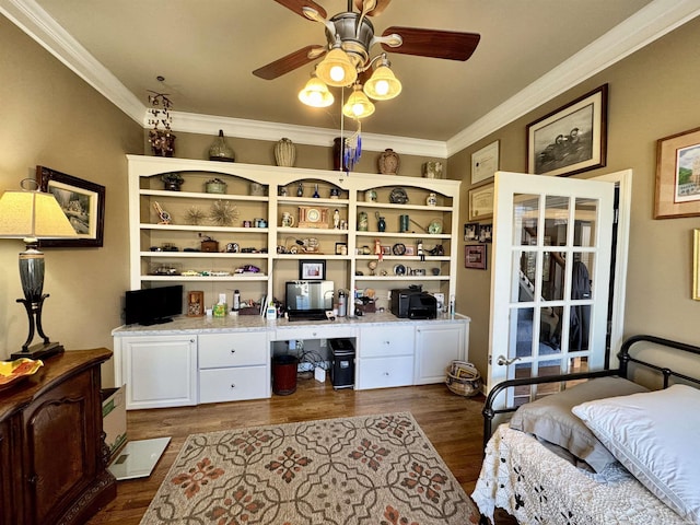 bedroom with dark wood-style floors, built in study area, and crown molding