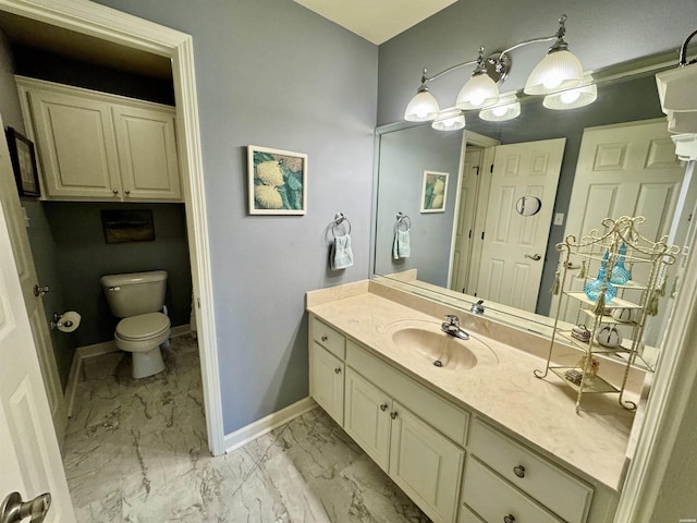 bathroom featuring toilet, marble finish floor, vanity, and baseboards