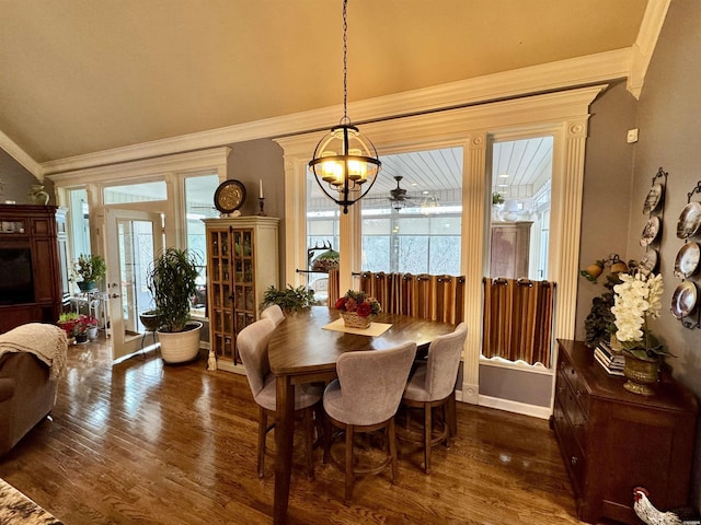 dining space featuring ornamental molding, a wealth of natural light, dark wood-style flooring, and vaulted ceiling