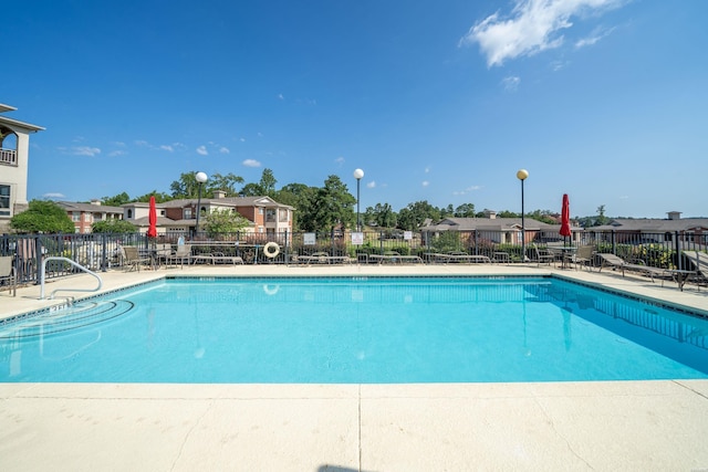 pool with a residential view and fence