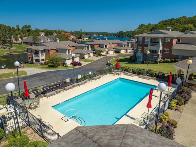 community pool featuring a patio area, a residential view, and fence