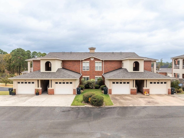 traditional-style home with a garage, a shingled roof, and brick siding