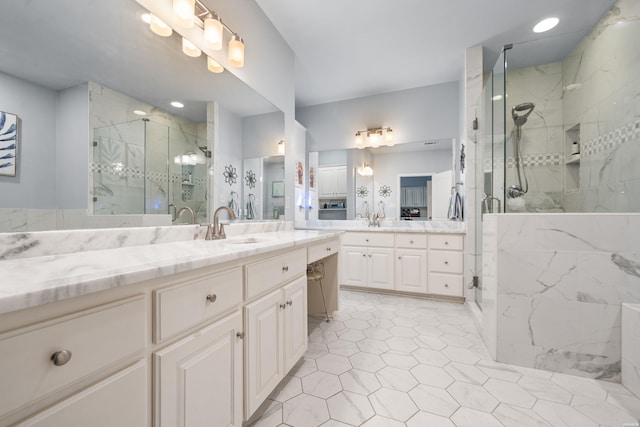 full bathroom featuring two vanities, a sink, and a marble finish shower