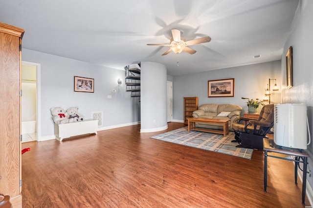 living area featuring baseboards, wood finished floors, visible vents, and a ceiling fan