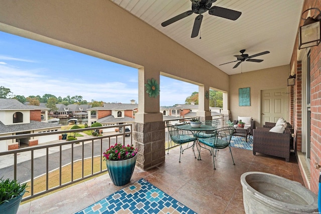 balcony with outdoor dining area, a residential view, and a ceiling fan