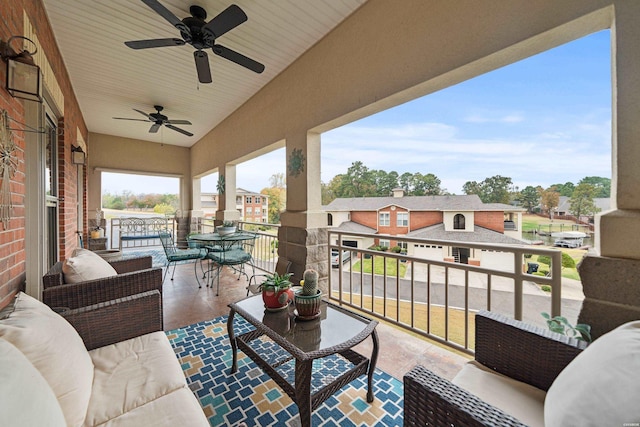 balcony with outdoor dining area, ceiling fan, and an outdoor hangout area