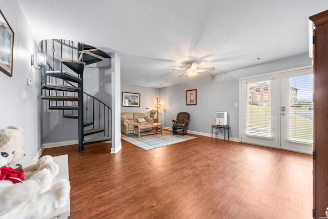 sitting room with stairway, wood finished floors, visible vents, and baseboards