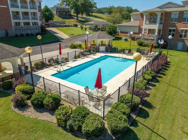 pool featuring a lawn, fence, a patio, and a gazebo