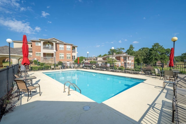 community pool with fence and a patio