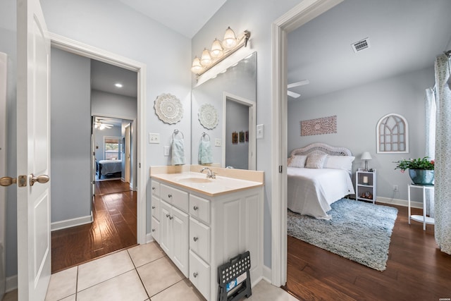 bathroom with ceiling fan, visible vents, wood finished floors, and ensuite bathroom