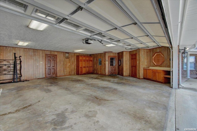 garage featuring a garage door opener and wood walls