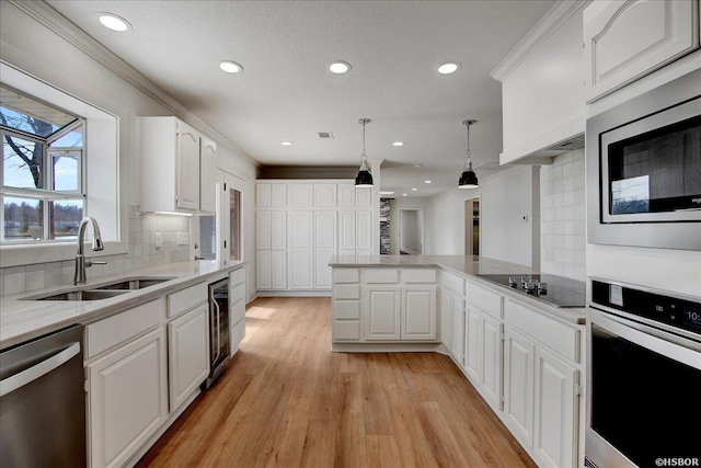 kitchen with appliances with stainless steel finishes, a sink, and white cabinets