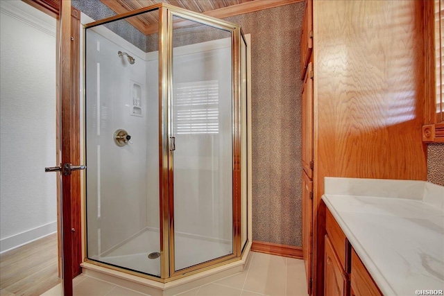 bathroom featuring a stall shower, vanity, and baseboards