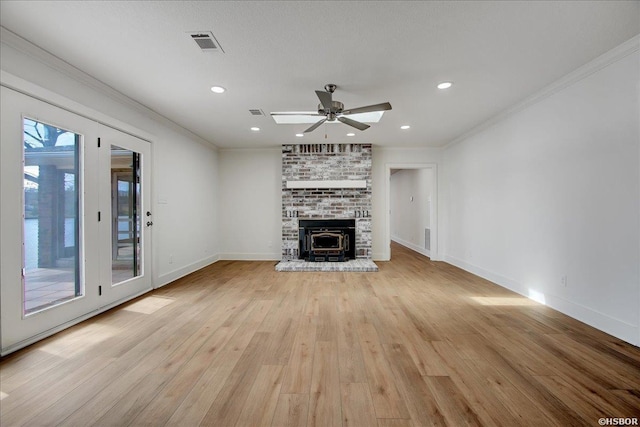 unfurnished living room featuring baseboards, light wood-style flooring, visible vents, and crown molding