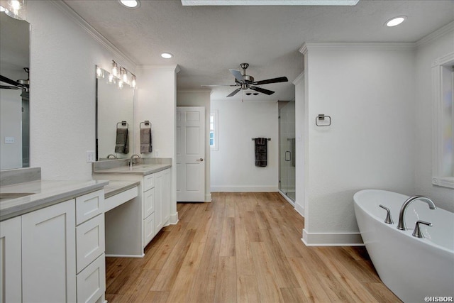 bathroom featuring crown molding, ceiling fan, a shower stall, wood finished floors, and a freestanding tub