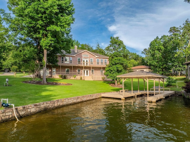 view of dock featuring a gazebo, a yard, and a water view