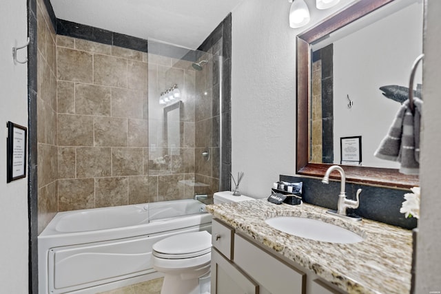 bathroom featuring toilet, a textured wall, tub / shower combination, and vanity