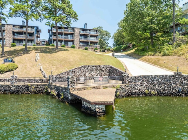 view of dock featuring a water view and fence