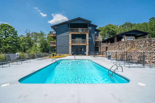 pool with fence and a patio