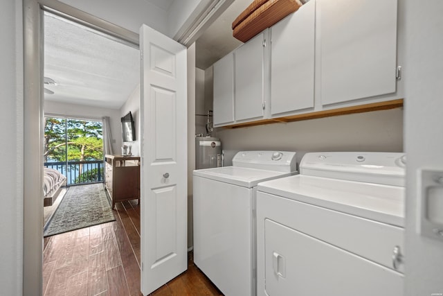 laundry room featuring washer and dryer, cabinet space, and dark wood finished floors