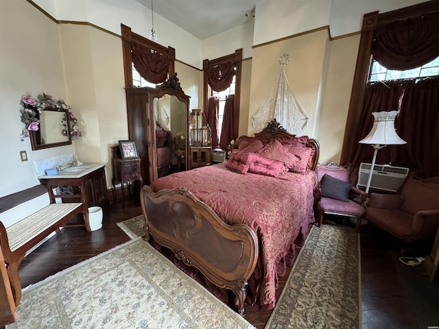 bedroom with dark wood-style flooring and an AC wall unit