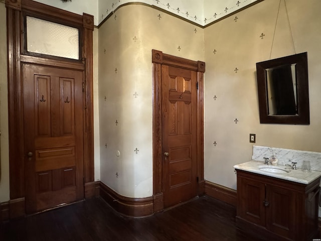 interior space with vanity, baseboards, and wood finished floors