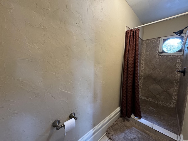 full bath featuring a shower stall and a textured wall