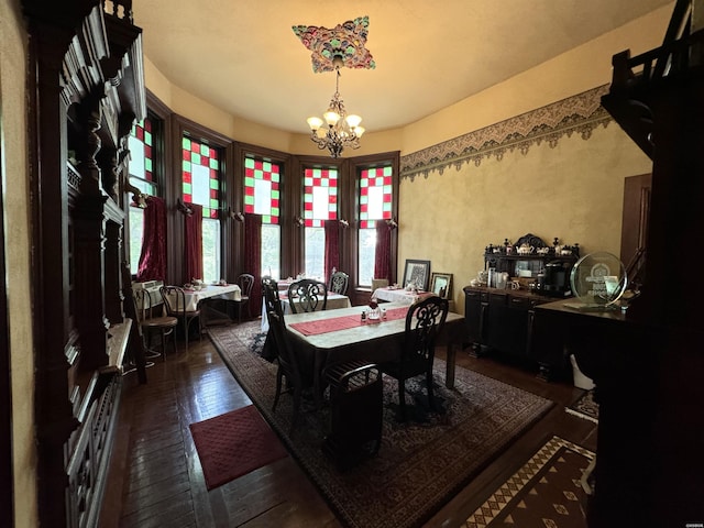 dining room with an inviting chandelier and dark wood-type flooring