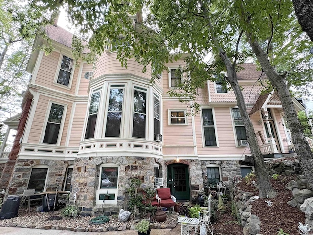 victorian home featuring stone siding