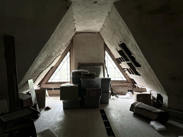 additional living space featuring lofted ceiling, plenty of natural light, and wood finished floors