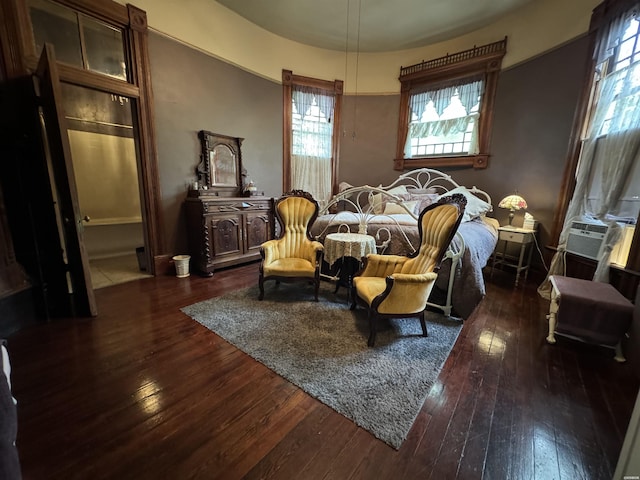 bedroom with cooling unit and dark wood finished floors