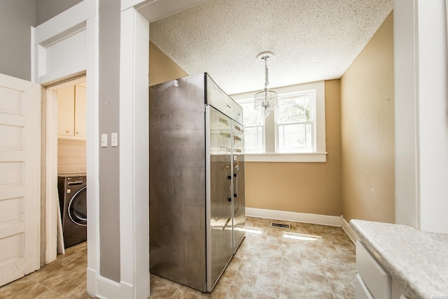 801 Crittenden St, Arkadelphia, AR 71923 - bathroom featuring a textured ceiling, a notable chandelier, visible vents, baseboards, and washer / dryer