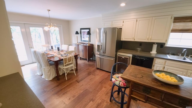 338 Sunset Bay Rd, Hot Springs, AR 71913 - kitchen featuring stainless steel fridge, dishwasher, white cabinets, light wood-style floors, and pendant lighting
