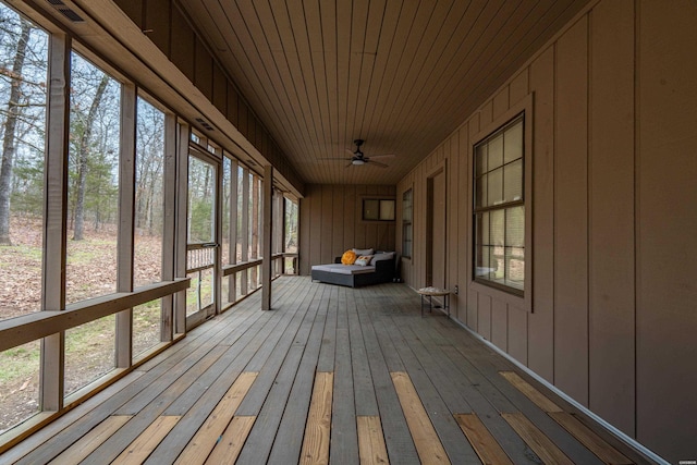 unfurnished sunroom with a ceiling fan, a wealth of natural light, wooden ceiling, and a sauna