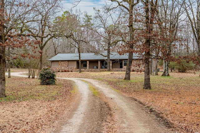 single story home with dirt driveway