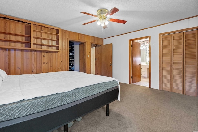 bedroom featuring light colored carpet, crown molding, a textured ceiling, and ensuite bathroom