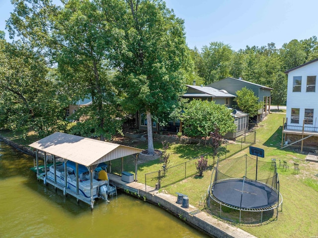 view of dock featuring a water view, boat lift, fence, and a lawn