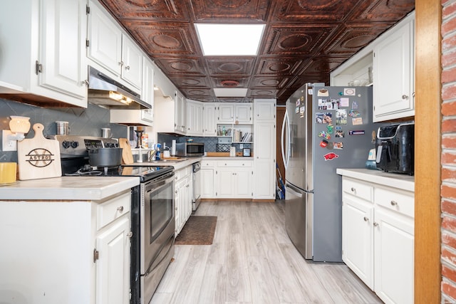 kitchen with an ornate ceiling, light countertops, appliances with stainless steel finishes, white cabinets, and under cabinet range hood