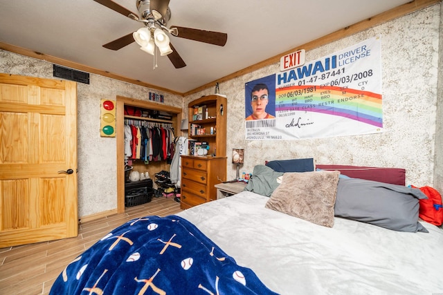 bedroom featuring ceiling fan, visible vents, a closet, and wood finish floors