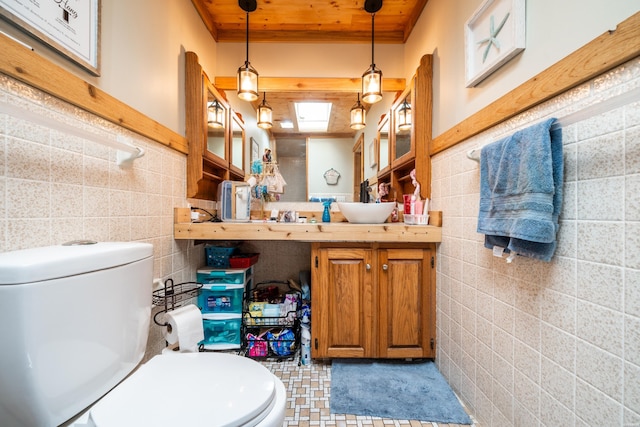 bathroom featuring toilet, wooden ceiling, tile walls, and vanity