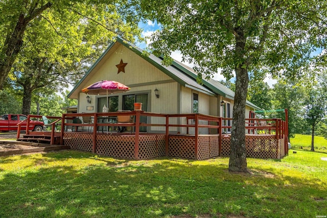 rear view of property featuring a deck and a yard